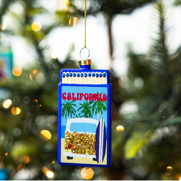 Decorative Christmas ornament with 'California' text and beach scene on a Christmas tree.