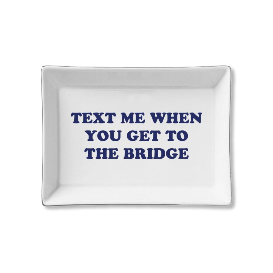 White rectangular plate with blue text 'TEXT ME WHEN YOU GET TO THE BRIDGE' on a white background
