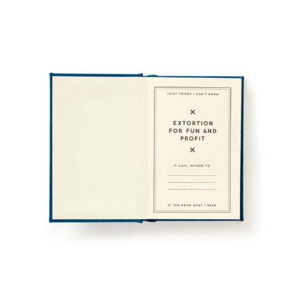 An open notebook or journal with a cream-colored page and a dark blue cover, photographed from above on a white background. The right page contains minimalist text and lined writing areas.