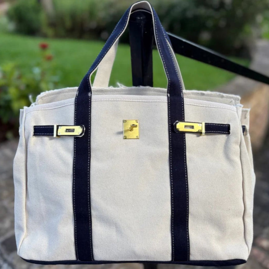 White bag with navy straps and gold accents 