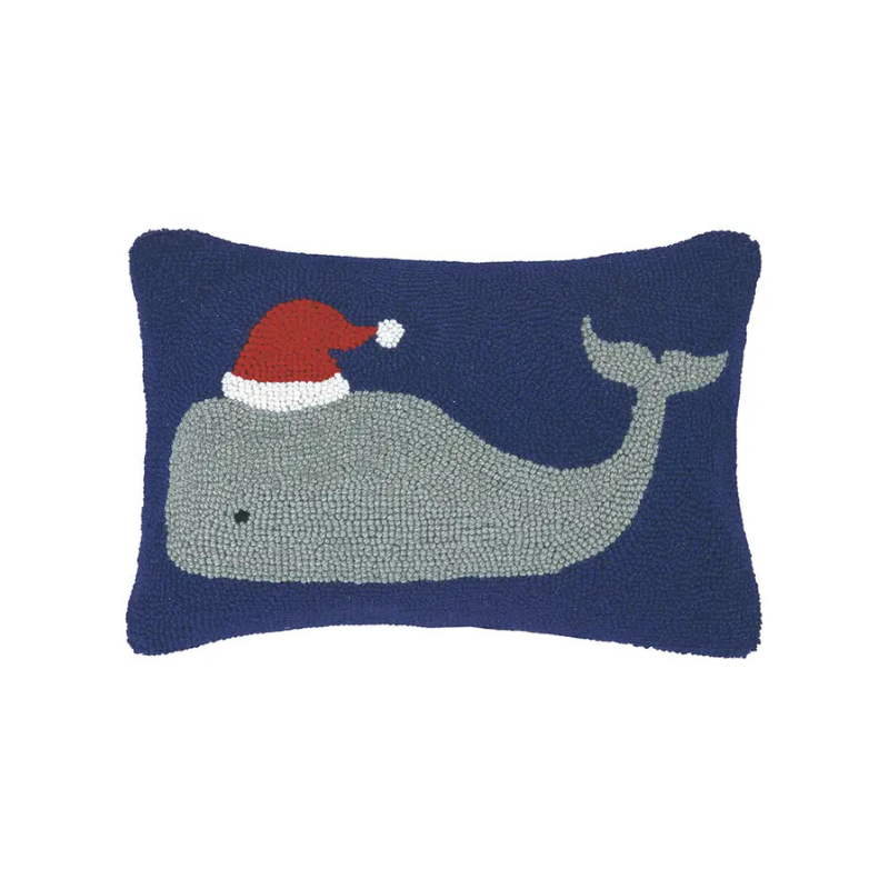 Decorative pillow with a whale wearing a Santa hat on a blue background