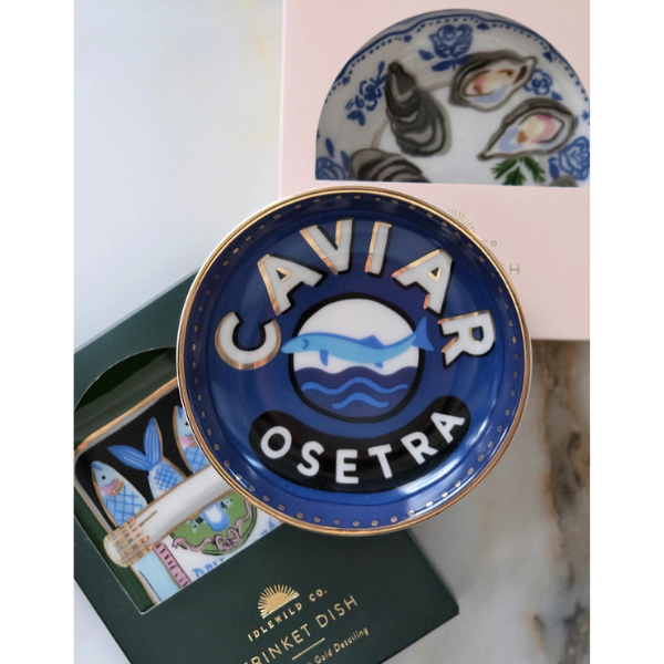 Blue 'Caviar Osetra' dish with gold rim on a marble surface