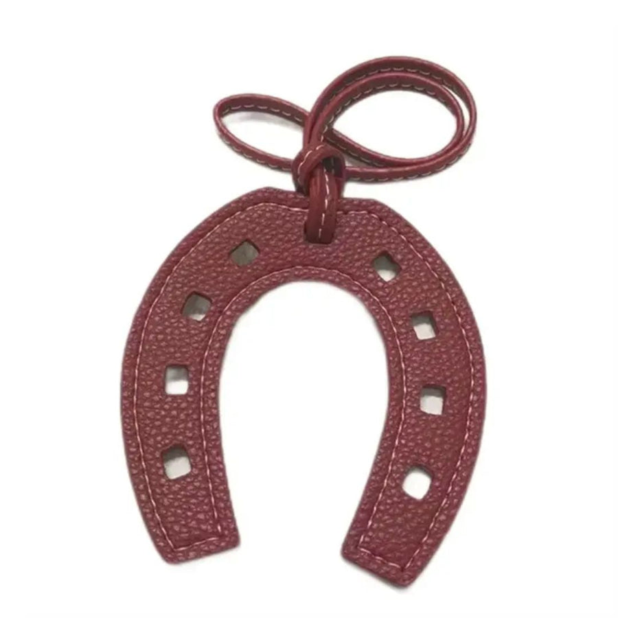 Maroon horseshoe-shaped keychain on a white background
