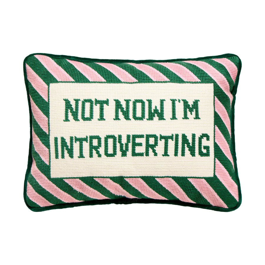Pillow with green and pink striped border and text 'Not Now I'm Introverting' on a white background
