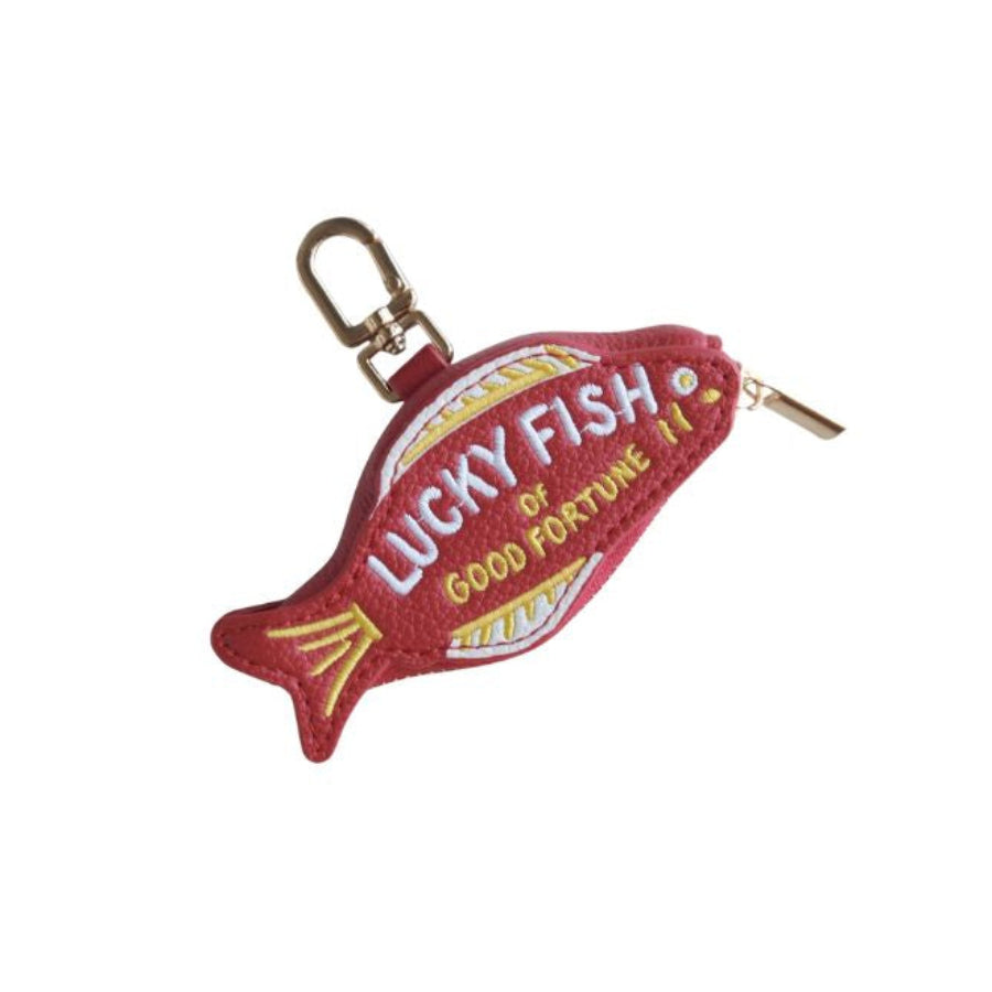 A red fish-shaped zipper pouch with 'LUCKY FISH OF GOOD FORTUNE II' embroidered on the front, featuring a gold metal clasp and zipper, set against a plain white background.
