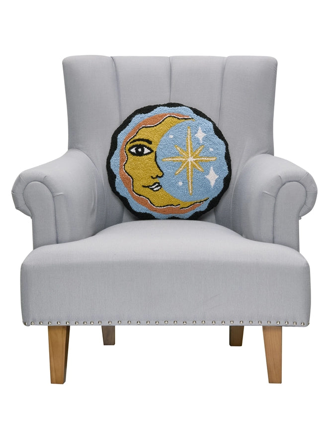 Decorative pillow with moon design on a gray armchair