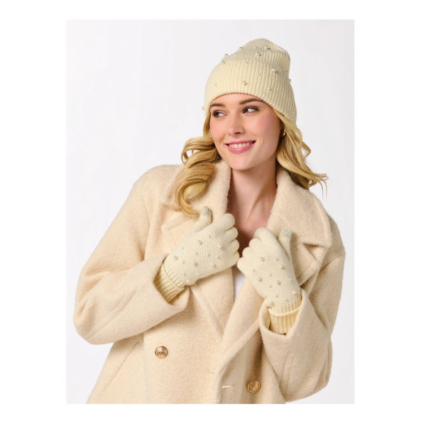Woman wearing a beige coat, hat, and gloves on a white background