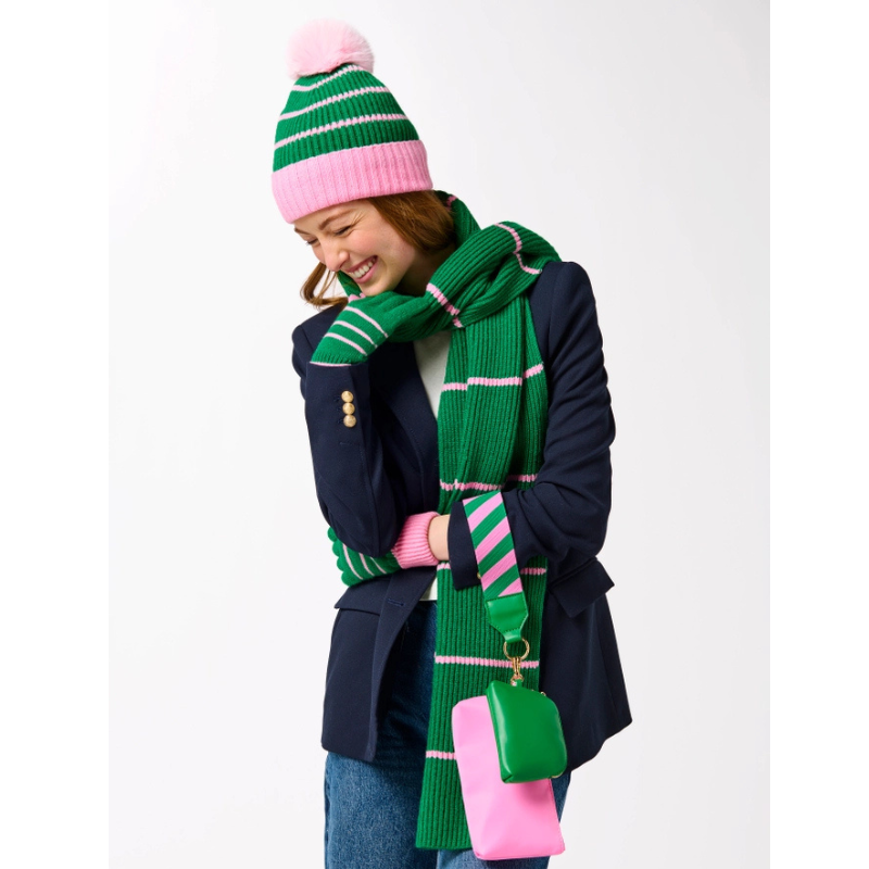 Person wearing a green and pink striped hat, scarf, and bag on a white background