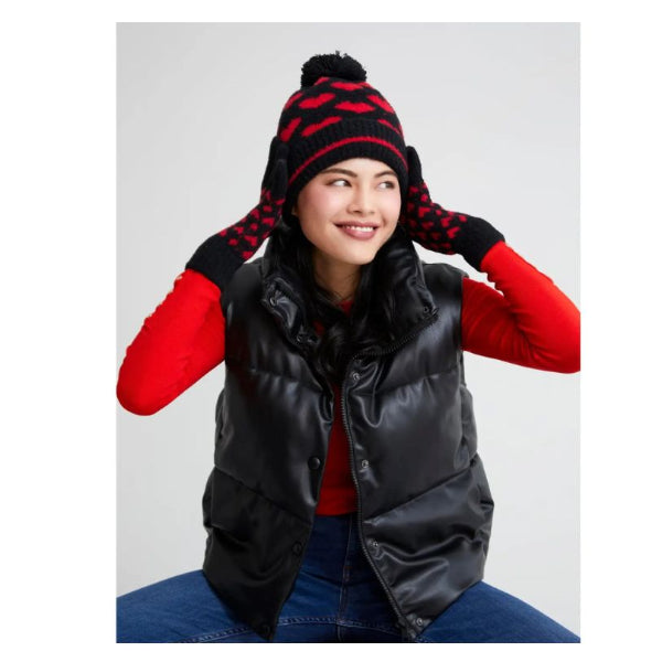 Person wearing a black puffer vest, red shirt, and patterned beanie on a white background