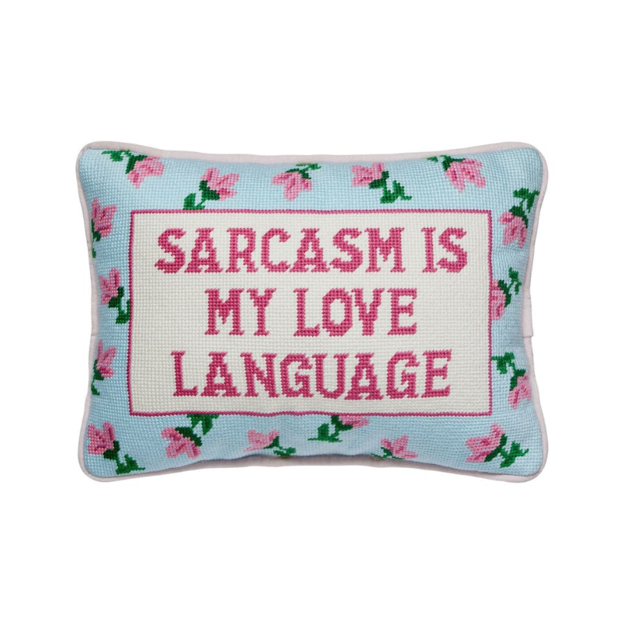 Decorative pillow with 'Sarcasm is my love language' text on a light blue background with floral patterns.